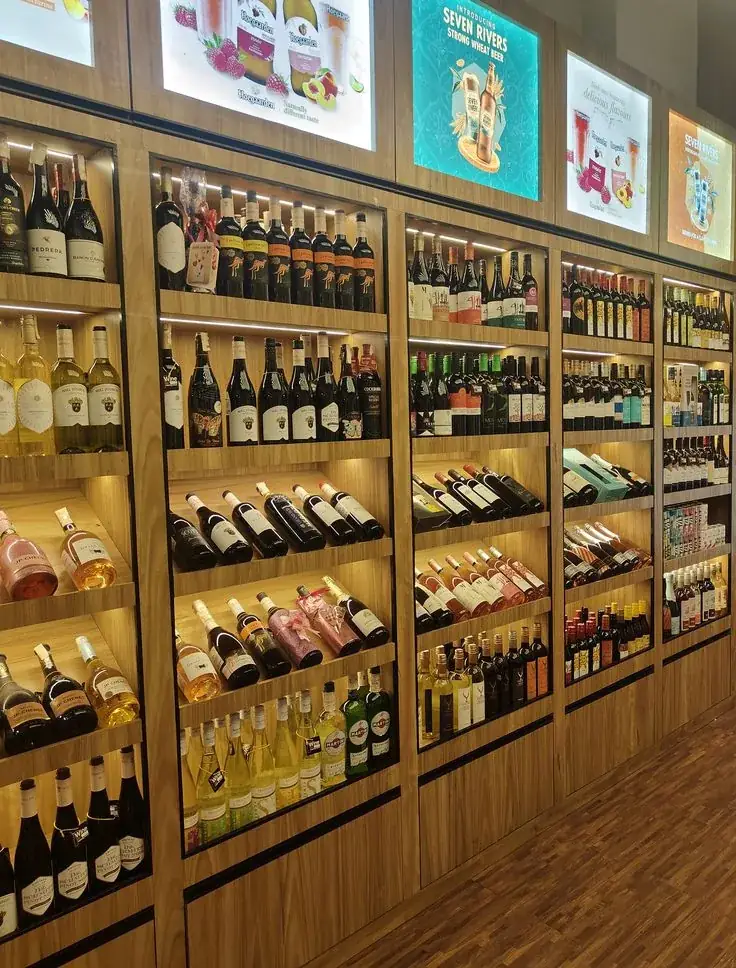 Liquor shop display shelving with backlit signage
